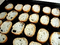 フランスパンは5mm厚に切り、天板に並べます。160度に温めたオーブンで10分ほどカリッと乾燥させます。