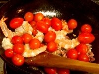 えびの色が変わってきたら、ミニトマトを加え、ミニトマトが少しやわらかくなるまで火を通す。 <br />
