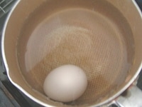 小鍋に卵、塩ひとつまみ、卵が隠れるよりも少し多めの水を入れて、火にかけ、固ゆで卵を作ります。お湯が沸騰したら弱火にして12分ゆでると固ゆで卵になります。<br />
<br />
ゆで卵は殻を剥き、4等分にします。<br />
<br />