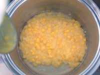 鶏の煮汁にクリームコーン缶と残りの水3カップを加え、中火で沸騰させます。<br />