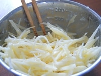 2のボウルに、1の細切りじゃがいも、小麦粉、塩を加えて、菜箸で小麦粉の粉っぽさがなくなるまで混ぜ合わせます。