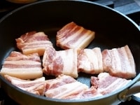 ねぎは5cmほどの長さに筒切りにする。豚バラ肉は5mm幅程度に切って塩こしょうし、フライパンを中火に熱して、豚バラを焼く。