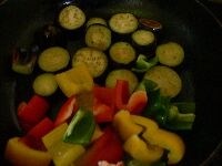フライパンを熱し、サラダ油を大さじ1加え、初めに茄子を並べて両面を焼き、 次に（油が足りないようであれば少し足して）ピーマンを加えて炒め合わせる。