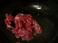 中華なべを熱し、サラダ油とごま油を入れ、叩いてつぶしたニンニクを炒めて香りを出して取り出し、牛肉を炒める。