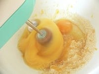 卵と砂糖をボウルに取り、50℃～60℃の湯煎にかけながら、ハンドミキサーの高速で泡立てる。<br />