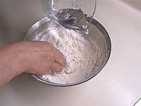 ふるった粉と塩をボウルにいれます。真ん中にくぼみを作り、ラードを入れます。ぬるま湯を少しずつ加え、よく混ぜ合わせます。ぬるま湯を使うとコシのある皮ができます。
