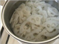鍋に塩ひとつまみを入れ、レンコンを約2分茹でます。茹で上がったレンコンはざるに上げ、よく水気を切ります。<br />