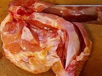 鶏肉は火が通りやすいよう、骨の両側に包丁で切り目を入れる。