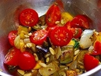 炒めた野菜をボールに取り、半分に切ったミニトマトを加え混ぜ合わせる。