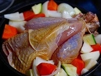 じゃがいもなどを敷いた鍋に鶏を入れ、さらに周りに余った野菜を詰めていく。皮にオリーブオイルを塗り、200℃に余熱したオーブンに入れて30分程度焼く。180℃に温度を下げ、さらに20分程度焼く。鶏を足が下になるように傾け、腹から流れる肉汁に赤い血が混ざっていなければ火が通っている。オーブンの性能によるが、大きな鶏の場合はさらに１時間程度は焼く必要がある。