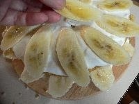 一番下のスポンジの上にホイップクリームをぬり、バナナを少しはみ出させて敷き詰め、 次のスポンジを裏表反対にしてのせ、クリームをぬり、バナナを敷き詰める。&rarr;繰り返す。