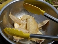 そのまま20分ほど煮たら、鶏手羽先・鶏胸肉（もも肉）を取り出し、粗熱が取れたら細く裂いておく。 <br />