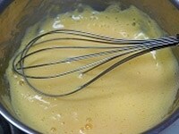 ボールにシャンパンと卵黄、塩を入れて湯煎にかけ、ザバイオーネを作る要領で泡だて器でとろりとするまでかき混ぜる。<br />
<br />
ふんわりとしたら味を見て、こしょう、塩（足りなければ）で調味する。 <br />
