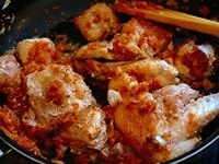 パプリカ、トマトピューレを加えて混ぜ、さらに炒めた塩豚、鶏肉、水、塩を加えて混ぜ合わせる。 <br />