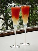 グラスにグレープフルーツとジュレをスプーンを使って交互に盛り付けてプチトマトとイタリアンパセリを飾ってできあがりです。<br />