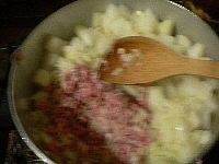 大根とコンニャクを寄せ、バターとサラダ油を入れ、ニンニクを炒めて香りを出し、挽き肉を加えて炒め合わせる。　