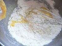 ふるいザル（又はふるい器）に、小麦粉とベーキングパウダーを取り、（3）にふるい入れ、牛乳を入れ、泡だて器で、粉っぽさがなくなる程度に混ぜる。　<br />