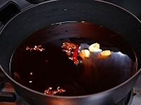 鍋に、紹興酒、昆布、ニンニク、生姜、赤唐辛子、砂糖と醤油を入れて、火にかけます。<br />