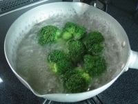 鍋に水を入れ沸騰したら、下茹で用の塩とブロッコリーを入れ、2～3分茹でます。軸が柔らかくなったらザルに上げ冷水に取ります。<br />