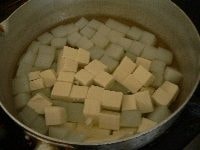 豆腐を1cm角に切って、（<b>2</b>）の鍋に加え、ひと煮立ちしたら火を止めて冷ます。 <br />