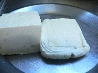 豆腐を電子レンジ（600W）に40秒かけ、皿をのせて水気を切る。