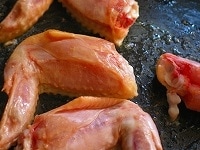 鶏もも肉を炒め終わったらボールなどに取り出し、続いて手羽先をやはり弱火で5分ほど、皮目からじっくり炒めます。<br />