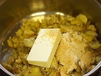 栗を鍋に移し、バターと砂糖を加えて、弱火にかけながら全体を混ぜ合わせる。<br />