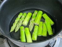 アスパラガスは根元近くの硬い皮をピーラーでむき、4等分に切る。鍋に湯を沸かし、沸騰したらアスパラガスを入れて2～3分ゆでる。