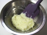 ラップを開き、キッチンペーパーを使いながら、皮をむきます（熱いので、火傷に注意）。<br />
<br />
ボウルに粗くつぶしたジャガイモを入れ、残ったかたまりを切るようにつぶします。 牛乳、塩を加え、なめらかになるよう、さっと（こね過ぎないよう）混ぜます。