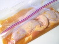 チャック付密閉ビニール袋に、マリネ液の調味料（オレンジジュース、マーマレード、はちみつ、醤油、塩、コンソメ、カレーパウダー）を入れ、ふり混ぜます。<br />
<br />
チキンを加えたら、空気を抜くようにして、しっかり封をします。調味料とチキンが馴染むよう、よく揉んだら、冷蔵庫で最低2、3時間から半日、寝かせます。<br />