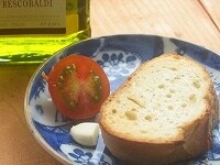 パンをトーストします。その間に、ニンニク、トマトを半分に切り、塩をオリーブオイルを用意しておきます。<br />