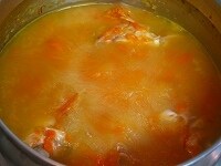 水と水煮トマトを加え、沸騰したら弱火にしてアクを取ります。そのまま30分以上煮込んで魚のスープを取ります。スープを漉して、塩で調味します。<br />