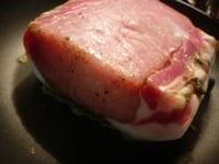 フライパンを火にかけ、1の豚肉を脂の面から焼きます。脂が適度に出てきたら、ひっくり返して、ブランデーを注ぎフランベします。表面に焼き色がついたら、焼き皿に移し替えます。<br />