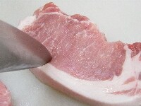豚ロースの赤身と脂肪の部分に切り込みを入れる