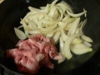 玉ねぎに少し焼き色がついたら向こう側に押して、豚肉を炒める。