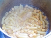 鍋にひよこ豆とブイヨンを入れ、火にかけます。煮立ったら、飲んでちょうど良い味になるまで塩を加え、マカロニを加えて茹でます（加える塩は、通常パスタを茹でるときより少な目になるはずです）。 <br />
