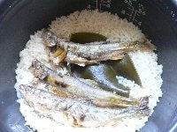 炊けたら昆布と鮎を取り出す。鮎の身をほぐしてごはんに戻し、さっくり混ぜる。