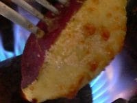 コンロの直火にかざし、表面についた砂糖を丁寧に焼く。箸を使ってフォークを抜く。