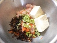 豆腐に皿を2枚ほど重ねて水切りする。（しっかり切らなくてよい） にんじんときくらげは1cm長さの千切り。青ねぎは粗みじん切り。 ねぎの白い部分は5cmに切って、縦に4つに切ってレンジ対応容器に入れておく。 <br />
<br />
ボールにひき肉、豆腐、にんじん、ねぎ、きくらげ、卵、醤油、片栗粉、手で砕いた麩を入れ、手で練るようによく混ぜる。 <br clear="all" />