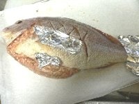 鯛の腹の中に（4.）をぎゅうぎゅう詰めにする。尾や胸のヒレが焦げ過ぎないよう、アルミホイルで包む。200℃のオーブンで40～50分かけてじっくり焼く。 <br />