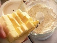 フードプロッセッサーに小麦粉と砂糖を入れて10秒ほど攪拌（かくはん）する。 次に1.5cm角に切ったバターを入れて攪拌し、均一のサラサラ状態にする。