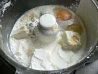 チーズケーキ生地の材料の、牛乳以外を全部フードプロセッサーに入れて混ぜ、均一になったら、1/4ほど残してボールにあけ、牛乳を加えてスイッチを入れて混ぜ、ボールにあけてゴムベラで混ぜる。