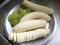 生地を冷ましてる間に、果物を用意し、生クリームに砂糖を加えて泡立てる。バナナの皮をむき、1本を5mm厚に切る。ブドウは皮をむく。柿の皮をむいて8等分に切る。レモン汁をふりかけておくと色が悪くならない。