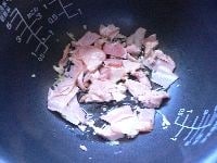 内釜の底に、ごま油小さじ2、生姜、にんにくを敷き、細く切ったベーコンとハムを入れる。