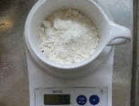 電子レンジ対応のコーヒーカップに、小麦粉を計り入れる。　
