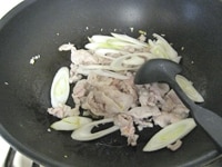 フライパンに、油、ニンニク、生姜のみじん切りを入れ、弱～中火にかけます。香りが立ったら、豚肉を加え、中火で炒めます。豚肉の色が変わったら、ねぎを加え、炒めます。<br />