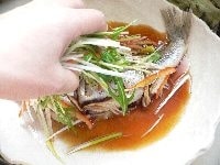 蒸し上がった魚を取り出し、青ネギ、生姜、蒸し汁を捨てる。魚を大皿にのせ、かけ汁をかけて野菜をのせる。