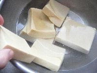 ボウルに熱湯を入れ、水を1カップ足し、高野豆腐を浸す。 <br />