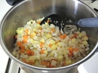 鍋に油を入れ、ニンニクを加え、中火にかけます。<br />
<br />
香りが立ったら、じゃがいも、たまねぎ、にんじん、レンコン、ごぼうを加え、油がまわるよう炒めます。