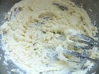 ボウルにバターを取り、ハンドミキサーで混ぜて軟らかくし、砂糖と塩を加えて白っぽくなるまでよく混ぜる。